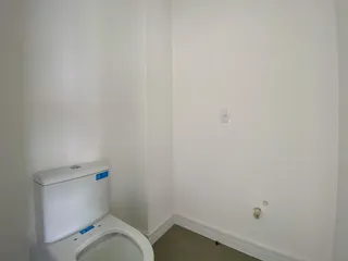 Foto de um banheiro com vaso sanitário branco e tomada na parede.