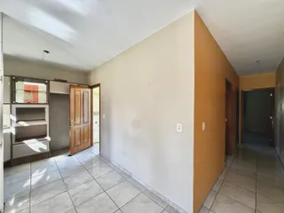 Hall de passagem com paredes claras e piso de cerâmica.