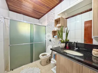 Foto de um banheiro com revestimento de azulejos e teto de madeira.