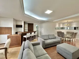 Sala de estar ampla com piso de madeira e móveis modernos.