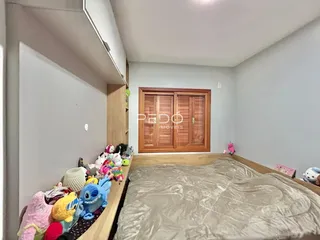 Quarto com cama e armário de madeira no interior da residência.