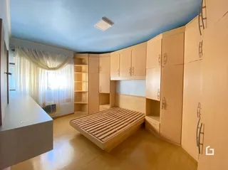 Quarto com armários embutidos e cama de madeira.