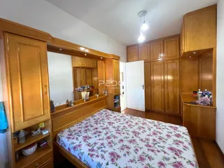 Quarto com armários em madeira e cama decorada.