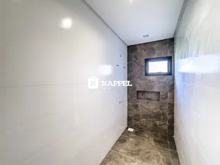Corredor com paredes brancas e uma parede de destaque escura.