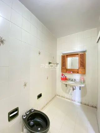 Um corredor com paredes brancas e piso de cerâmica.