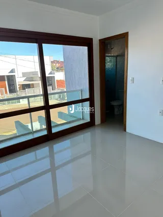 Vista da sala com piso de cerâmica e grande janela.