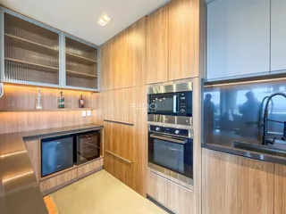 Cozinha moderna com armários de madeira e eletrodomésticos de aço inoxidável.