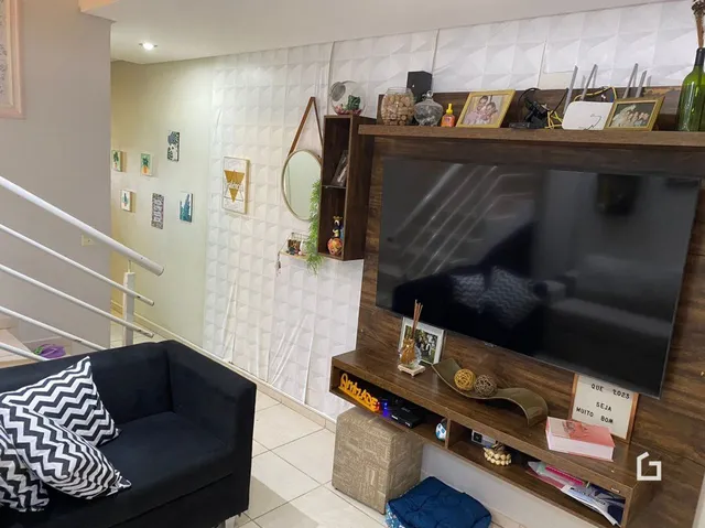 Sala de estar com sofá e painel de madeira para televisão.