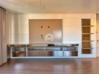 Ambiente interno de uma sala com piso de madeira e painel decorativo.
