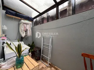 Vista interna de um ambiente com janela de telhado e máquina de lavar roupa.