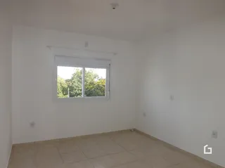 Sala de estar com paredes brancas e piso de cerâmica.