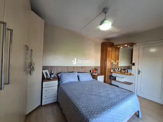 Quarto com cama e armários de madeira no interior da residência.