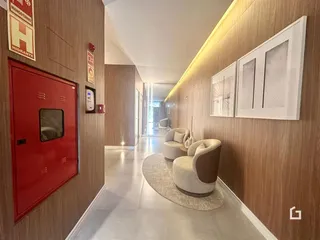 Corredor interno de uma residência com paredes de madeira e área de estar.