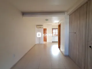 Corredor interno com piso claro e paredes brancas, mostrando a profundidade do ambiente.