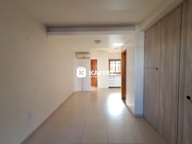 Corredor interno com piso claro e paredes brancas, mostrando a profundidade do ambiente.