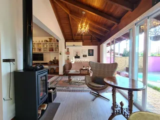 Sala de estar com piso de madeira e portas de vidro que dão para o exterior.