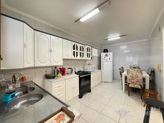 Foto de uma cozinha com armários brancos e piso cerâmico em Lajeado.