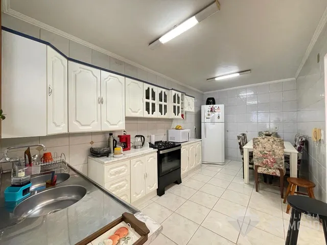 Foto de uma cozinha com armários brancos e piso cerâmico em Lajeado.