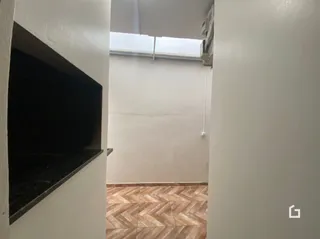 Vista interna de um corredor com paredes brancas e piso de cerâmica.