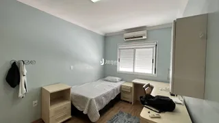 Quarto com cama e janela em sala de um imóvel.