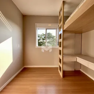 Um cômodo interno com piso de madeira e janela de vista para a vegetação.