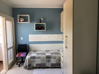 Quarto com paredes azul e cama de casal.