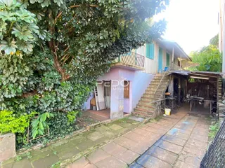 Vista externa de uma residência em Lajeado, Brasil, com jardim e escadaria de acesso.