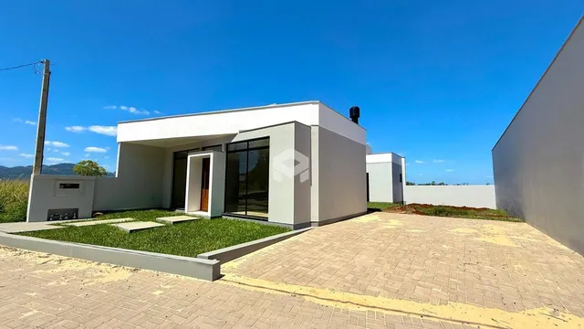 Fachada externa de uma residência moderna em Lajeado, Brasil, com paisagismo frontal.
