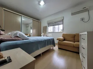 Quarto com cama e sofá em ambiente interno.