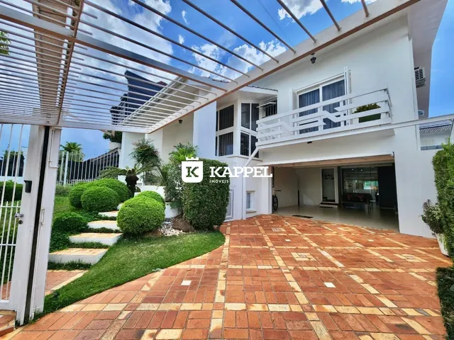 Fachada de uma casa moderna em Lajeado, Brasil, com paisagismo frontal e área pavimentada.