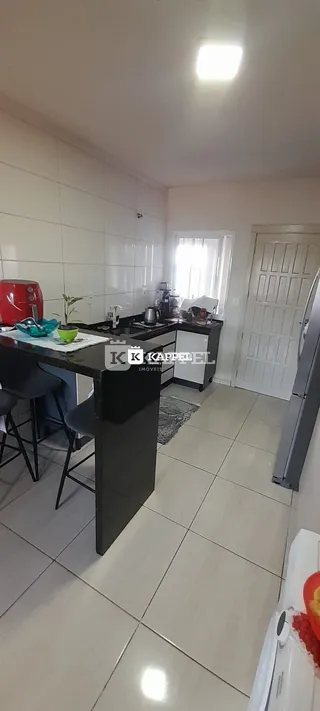 Esta é uma foto da cozinha com bancadas escuras e eletrodomésticos.
