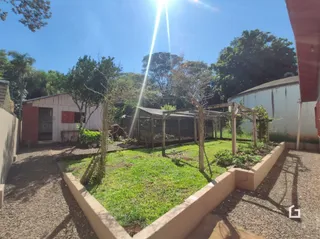 Vista de um jardim gramado cercado por postes de madeira.