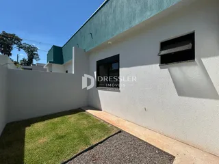Vista externa de uma casa branca com telhado verde e jardim.