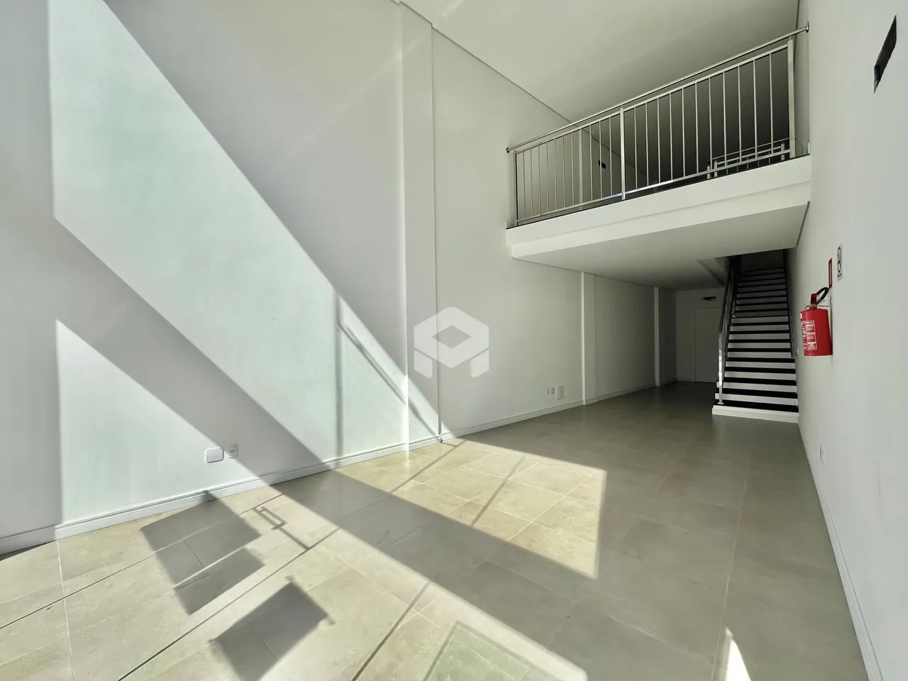 Hall de entrada com vista para a varanda e escadaria.