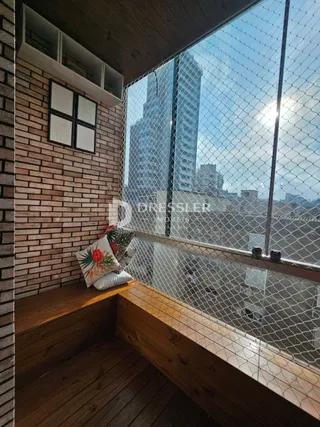 Vista de uma sala com parede de tijolos e varanda em Lajeado, Brasil.