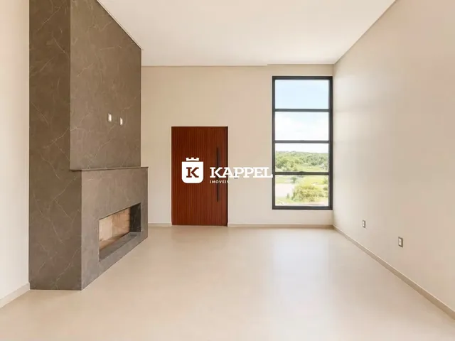 Sala de estar com paredes brancas e uma lareira moderna.