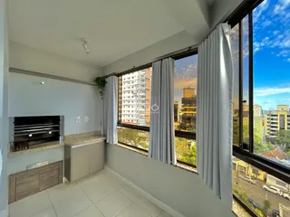 Sala de estar com grande janela oferecendo vista da cidade.
