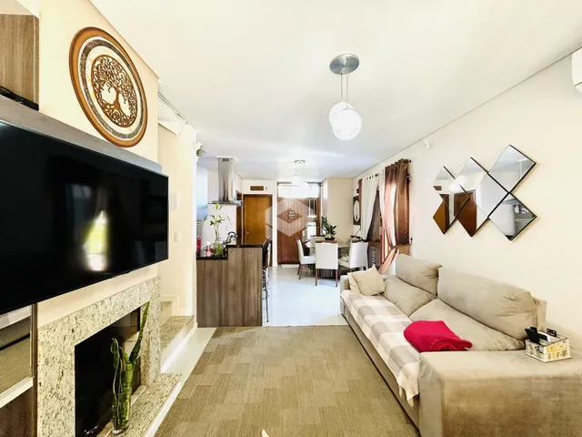 Sala de estar com lareira e vista para a área de jantar e cozinha.