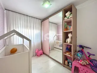 Quarto com paredes brancas e piso claro em uma residência.