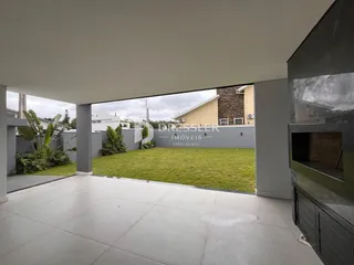 Vista externa de uma área de lazer com gramado e muro em Lajeado, Brasil.