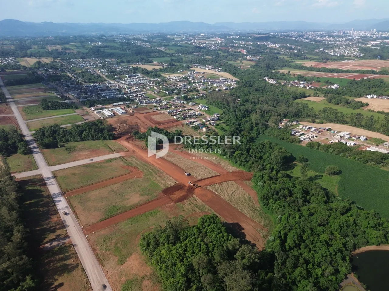 Vista aérea de uma área rural com campos e vegetação ao redor.