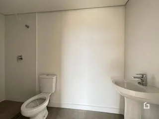 Foto de um banheiro interno com vaso sanitário e pia brancos.