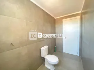 Foto de um banheiro interno com vaso sanitário branco e piso claro.
