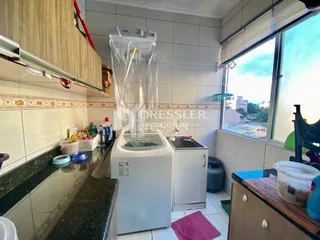 Vista interna de uma cozinha com revestimento de cerâmica e janela.