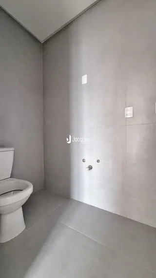 Foto interna de um banheiro com piso de cerâmica e azulejos brancos.