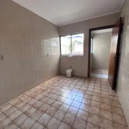 Vista interna de um corredor com piso de cerâmica clara.