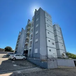 Fachada de um prédio residencial alto em Lajeado, Brasil, sob céu azul.