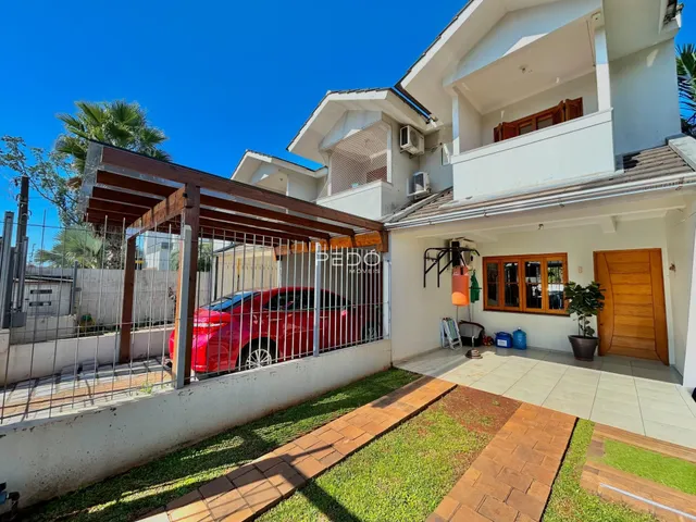 Vista externa de uma residência em Lajeado, Brasil, com jardim e cerca de madeira.