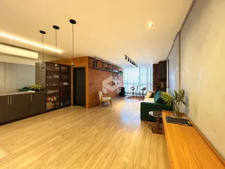 Ambiente interno de sala de estar com piso de madeira clara.