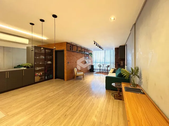 Ambiente interno de sala de estar com piso de madeira clara.